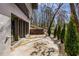 Backyard patio area with lush greenery, landscaping, and a retaining wall at 110 Maryeanna Ne Dr, Atlanta, GA 30342