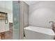 Bathroom featuring a standalone soaking tub, glass-enclosed shower, and neutral stone tiling at 110 Maryeanna Ne Dr, Atlanta, GA 30342