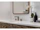 Close up of a bathroom sink with modern fixtures, quartz countertop, and a decorative mirror at 110 Maryeanna Ne Dr, Atlanta, GA 30342