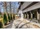 Back patio view with a row of arborvitae trees, exterior lighting and access to the home at 110 Maryeanna Ne Dr, Atlanta, GA 30342