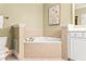 Neutral bathroom featuring a tiled tub, updated vanity, and elegant artwork at 560 Dutch Valley Ne Rd # 209, Atlanta, GA 30324