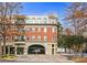 Upscale multi-story building with brick facade and wrought iron balconies overlooking street access to retail and covered parking at 560 Dutch Valley Ne Rd # 209, Atlanta, GA 30324