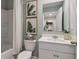 Clean bathroom with white vanity, shower, and decorative prints at 2094 Moss Hill Road, Stone Mountain, GA 30088