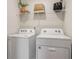 Bright laundry room with washer, dryer, and overhead shelving at 2094 Moss Hill Road, Stone Mountain, GA 30088