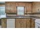 Traditional kitchen featuring granite countertops, wood cabinets, tile backsplash, and white appliances at 72 Bishop Nw Dr, Cartersville, GA 30121