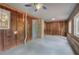 Enclosed sunroom with wood paneling, brick accents, concrete flooring, and ceiling fan at 72 Bishop Nw Dr, Cartersville, GA 30121
