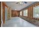 Enclosed sunroom with wood paneled walls, large windows, brick accents and concrete flooring at 72 Bishop Nw Dr, Cartersville, GA 30121