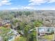 Aerial view of a home with a pool and an inset picture of the front of the house with city views in the distance at 4540 Club Valley Ne Dr, Atlanta, GA 30319