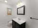 Clean bathroom features a dark vanity with bright countertop and framed mirror, and a single window at 4540 Club Valley Ne Dr, Atlanta, GA 30319