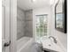 Bright bathroom with tiled shower, vanity sink and window view at 4540 Club Valley Ne Dr, Atlanta, GA 30319