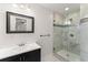 Modern bathroom with tiled shower, glass door, dark vanity, and white countertop with framed mirror at 4540 Club Valley Ne Dr, Atlanta, GA 30319
