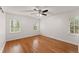 Well-lit bedroom features hardwood floors, light walls, ceiling fan and natural light from two large windows at 4540 Club Valley Ne Dr, Atlanta, GA 30319