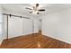 Bright bedroom with wood floors, ceiling fan and sliding barn door at 4540 Club Valley Ne Dr, Atlanta, GA 30319
