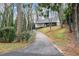 View of the home down a long driveway lined with trees and manicured foliage at 4540 Club Valley Ne Dr, Atlanta, GA 30319