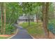 Charming home featuring a stone facade, black shutters, and a long, winding driveway through a lush green landscape at 4540 Club Valley Ne Dr, Atlanta, GA 30319