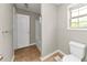 Well-lit bathroom with a toilet, window, and shower, featuring tiled flooring at 1016 Weatherwood Pl, Conyers, GA 30012