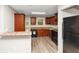 The kitchen features black appliances, wood-look flooring, and wood cabinets at 1016 Weatherwood Pl, Conyers, GA 30012