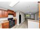 A kitchen featuring brown cabinets, a black refrigerator, and access to the living room at 1016 Weatherwood Pl, Conyers, GA 30012