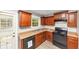 A kitchen featuring brown cabinets, a black dishwasher, and a black oven at 1016 Weatherwood Pl, Conyers, GA 30012