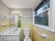 Bathroom with yellow tile, toilet, and sink at 2458 Haverford Way, Decatur, GA 30032