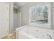 Inviting bathroom with soaking tub, large window and private toilet area at 20 Trace Ct, Covington, GA 30016