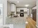 Bright kitchen with stainless steel appliances, granite countertops, and wood-look flooring at 20 Trace Ct, Covington, GA 30016