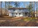 Back exterior view with deck and covered patio, surrounded by trees at 4064 Chimney Ridge Way, Ellenwood, GA 30294