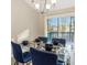 Stylish dining room with a modern glass table and elegant blue chairs, creating a welcoming space at 4064 Chimney Ridge Way, Ellenwood, GA 30294