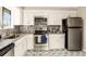 Bright kitchen features stainless appliances, granite counters and attractive backsplash and flooring at 4064 Chimney Ridge Way, Ellenwood, GA 30294