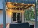 Cozy covered patio with string lights, comfortable seating, and access to the backyard at 4064 Chimney Ridge Way, Ellenwood, GA 30294