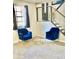 Sitting area in the home features two blue velvet chairs with gold legs and an open stairwell at 4064 Chimney Ridge Way, Ellenwood, GA 30294