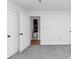 Bright bedroom with grey carpet, double doors to closet, and access to bathroom at 7771 Mattie Mccoy Ln, Winston, GA 30187