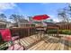 This large, wooden deck features an umbrella table and chairs and is surrounded by mature landscaping at 2425 Park Ave, Austell, GA 30106