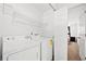 Bright laundry room with a white washer and dryer, shelving, and access to the bedroom at 2425 Park Ave, Austell, GA 30106