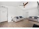 Open living room area with hardwood floors, ceiling fan, and light gray sofas at 2425 Park Ave, Austell, GA 30106