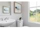 Bathroom featuring a pedestal sink, toilet, window with a view, and modern fixtures at 2656 Brookview Nw Ln, Atlanta, GA 30318