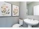 Elegant powder room with modern fixtures, stylish artwork, and a sleek pedestal sink at 2656 Brookview Nw Ln, Atlanta, GA 30318