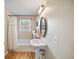 Small bathroom featuring a pedestal sink, and combination tub and shower with curtain over wood look floors at 85 Sara Dr, Covington, GA 30016