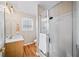 Bathroom featuring a glass shower, wood-look floors, light wood vanity, and a window providing natural light at 85 Sara Dr, Covington, GA 30016