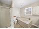 Bathroom includes a shower stall, a jetted tub with marble surround, a toilet, and a window for natural lighting at 85 Sara Dr, Covington, GA 30016