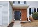 Dark-colored front door with brick surround and landscaping at 132 Timber Mist Ln, Lawrenceville, GA 30045