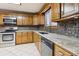 Kitchen boasts wood cabinets, granite countertops, and stainless steel appliances at 2020 Temple Johnson Rd, Loganville, GA 30052