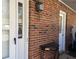 Close-up of the brick entrance, white door and a small table decor at 5950 Wintergreen Rd, Norcross, GA 30093