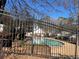 Community pool surrounded by fencing, with trees in the background at 5950 Wintergreen Rd, Norcross, GA 30093