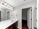 Bathroom with vanity, mirror, and dark wood cabinets at 7502 Springbox Dr, Fairburn, GA 30213