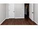 Bright bedroom with hardwood floors and neutral walls, two doors at 7502 Springbox Dr, Fairburn, GA 30213
