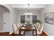 Formal dining room with hardwood floors, chandelier, and seating for eight at 7502 Springbox Dr, Fairburn, GA 30213