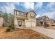 Two-story house with a two-car garage and landscaping at 7502 Springbox Dr, Fairburn, GA 30213