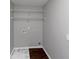 Bright laundry room with wire shelving and dark wood-look flooring at 7502 Springbox Dr, Fairburn, GA 30213