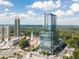 Aerial view of a modern high-rise residential building surrounded by trees on a sunny day at 3630 Peachtree Ne Rd # 2104, Atlanta, GA 30326